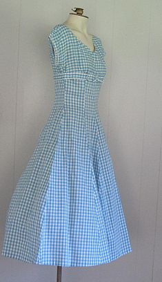 DESCRIPTION 1950s cotton dress Blue and white gingham Wide v-neck embellished with rhinestones and beads Under bust bow Fitted bodice/waist and full skirt Hand made Narrow white rick rack trim APPROXIMATE MEASUREMENTS (INCHES): Bust: 33 Waist: 26 Hip: OPEN Bodice (shoulder to waist): 15 Skirt (waist to hem): 30 CONDITION Excellent/very good. The under arms on both sleeves have been repaired/reinforced. Aside from this, the dress appears unworn. 1950s Style Gingham Dress For Picnic, 1950s Style Gingham Fitted Dress, Fitted Lined Gingham Dress, Fitted Gingham Dress For Garden Party, Elegant Plaid Cotton Dress, Fitted Gingham Dress For Picnic, Fitted Gingham Dress For Picnics, 1950s Style Gingham Cotton Dress, Gingham Cotton Dress For Daywear