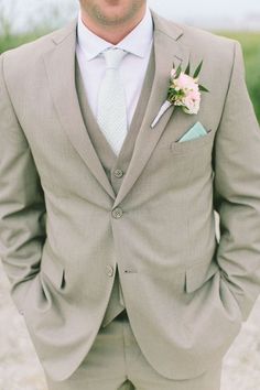 a man wearing a suit and tie with a boutonniere on his lapel