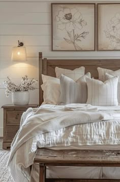 a bed with white sheets and pillows in a bedroom next to two pictures on the wall