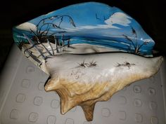 a ceramic sculpture of a beach scene with seagulls flying over the water and sand dunes