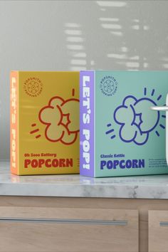 two popcorn boxes sitting on top of a counter next to an electric toothbrush holder