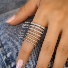 a woman's hand with four different rings on her fingers and one ring in the middle