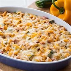 a casserole dish with cheese and vegetables on the side