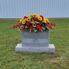 a headstone with flowers on it in the grass