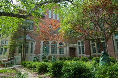 an old brick building surrounded by trees and bushes