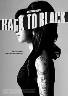 a woman with tattoos on her arm and shoulder is standing in front of a poster that says, back to black