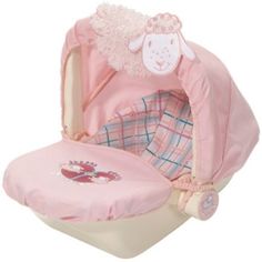 a pink baby seat with a sheep on it's back and its hood up