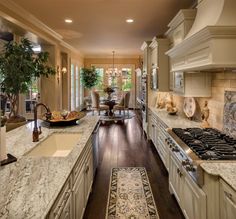 a large kitchen with white cabinets and marble counter tops