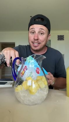 a man holding a pitcher filled with ice and lemons