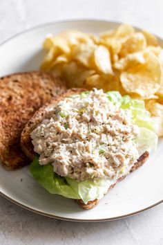 a white plate topped with a sandwich and chips
