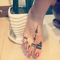 a woman's foot with tattoos on it and a potted plant in the background