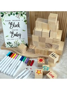 wooden blocks and crayons on a table next to a book with the words block baby