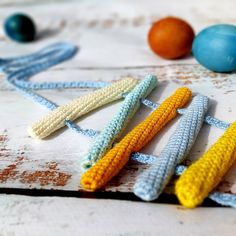 crocheted corn on the cob is laying next to an egg and two eggs