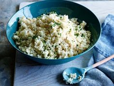 a blue bowl filled with rice on top of a table