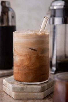 a drink sitting on top of a counter next to a blender