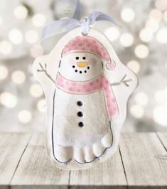 a snowman ornament hanging on a wooden table