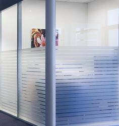 an office cubicle with white slats on the wall and blue carpeted floor