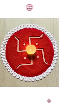 a candle that is sitting in the middle of a red circle with white circles around it