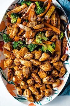 a plate with chicken, broccoli and carrots on it next to a fork