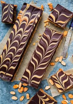 chocolate and peanut butter swirled dessert bars on parchment paper with spoons next to them