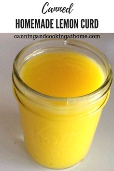 a glass jar filled with homemade lemon curd sitting on top of a white table