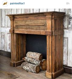 an old wooden fireplace with logs on the floor