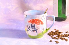 a coffee cup with totoro and an umbrella on it next to some dry dog food