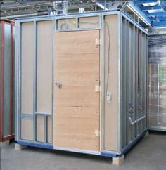 a portable toilet in a storage room with wood doors and metal frame around the door