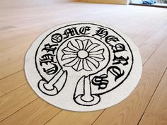 a white rug with black writing on it in the middle of a wood floored room