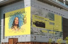 an advertisement on the side of a building with a woman's face in blue and yellow