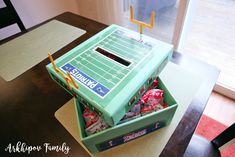 a cake made to look like a football game in a box with candy wrapped around it