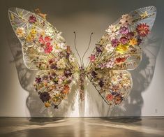 a large butterfly made out of flowers on display