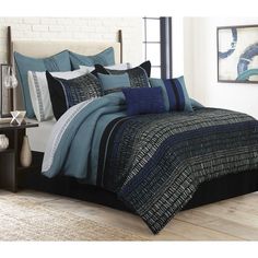 a bed with blue and black comforters in a room