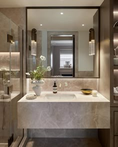 a modern bathroom with marble counter tops and walls