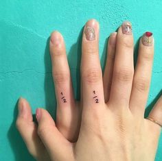 two fingers with small tattoos on them, one has the word love written on it