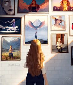 there is a woman standing in front of pictures on the wall with her back to the camera