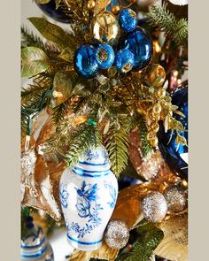 a blue and white vase sitting on top of a table next to christmas tree ornaments