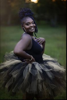 a woman with dreadlocks is posing for a photo in a tutu skirt