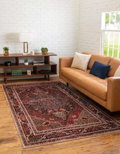 a living room with a couch, chair and rug