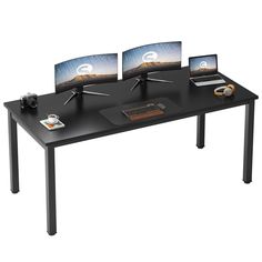 three computer monitors sitting on top of a black table next to a laptop and mouse