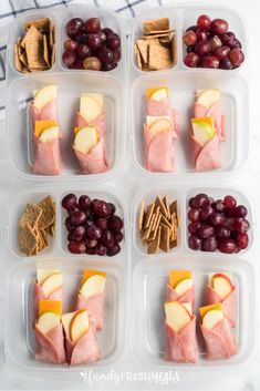 a plastic container filled with grapes, crackers and meats next to other food items