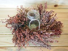 dried flowers are arranged in a circle on a wooden surface, ready to be used as a wreath