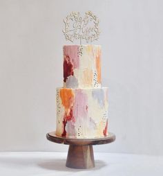 a multicolored cake on a wooden stand