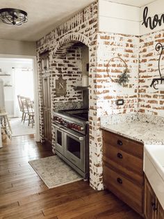 a kitchen with brick walls and wooden floors