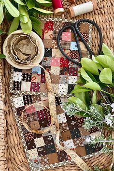 a basket filled with lots of green plants next to scissors and other things on top of it