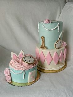 two cakes decorated with pink, blue and white frosting