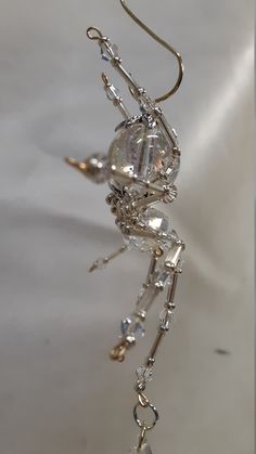 a metal spider with crystal beads hanging from it's back