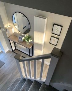 an overhead view of a staircase with pictures on the wall and a mirror above it