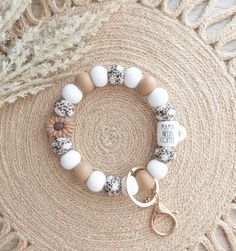 a close up of a bracelet on a rug with a keychain and flower