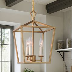 a chandelier hanging from the ceiling in a kitchen with potted plants on the counter